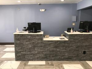 a lobby with a stone counter with two monitors on it at Days Inn by Wyndham Rawlins in Rawlins