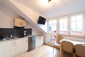 a kitchen and dining room with a table at Apartamenty Vasco da Gama- blisko plaży in Rowy