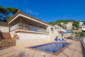 een huis met een zwembad voor een huis bij Villa Breeze in Lloret de Mar