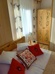 a bedroom with a bed with red pillows on it at Willa Polka in Bukowina Tatrzańska