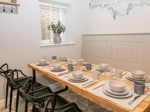a dining room with a wooden table and chairs at Greenwell Cottage in Chesterfield