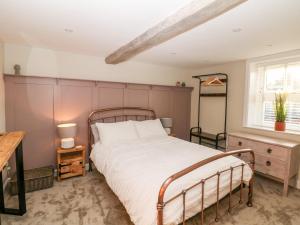 a bedroom with a large bed and a window at Greenwell Cottage in Chesterfield
