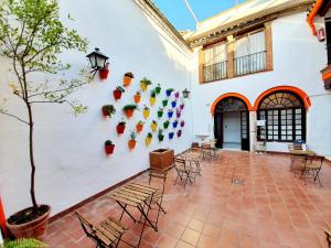 a courtyard with chairs and a wall with plants at Arc House Córdoba Only Adults in Córdoba