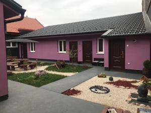 a purple house with a patio and a yard at Zen apartman 1 in Zrenjanin