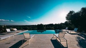 una piscina con sedie a sdraio e una piscina di Relais Trulli Le Icone a Ostuni