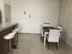 a dining room with a table and white chairs at RESIDENCIAL SANTANA 104 in Florianópolis