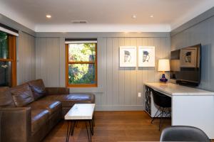 a living room with a leather couch and a television at Cedar Crest - Stellar's Jay Cottage 4 in Homewood