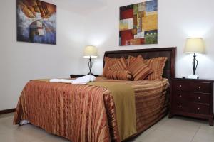a bedroom with a large bed with two lamps on it at Suites Jardín Imperial in Guatemala