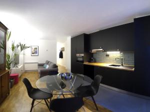cocina y sala de estar con mesa de cristal y sillas en Luxury Cuchillería Vitoria, en Vitoria-Gasteiz