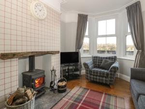 a living room with a fireplace and a stove at Brinkburn Cottage in Scarborough