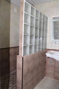 a bathroom with a glass shelf next to a sink at Residence Nadra in 'Aïn el Turk