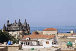 a group of buildings with a castle in the background at Residence Nadra in 'Aïn el Turk