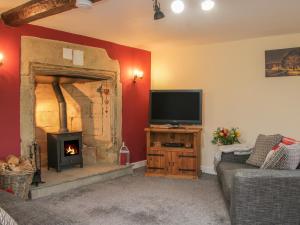 a living room with a tv and a fireplace at Belmont Bridge in Oswestry