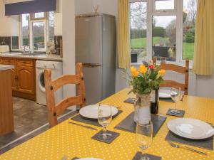 eine Küche mit einem Tisch mit Tellern und Blumen darauf in der Unterkunft Belmont Bridge in Oswestry