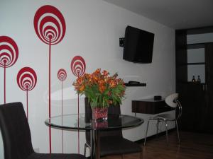 Zimmer mit einem Glastisch mit einer Blumenvase in der Unterkunft Europa Hotel Boutique Manizales in Manizales