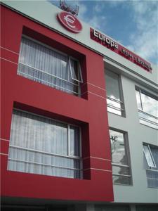 un bâtiment rouge et blanc avec un panneau sur celui-ci dans l'établissement Europa Hotel Boutique Manizales, à Manizales