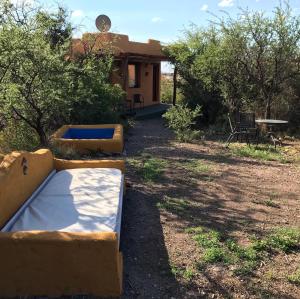 卡皮亚德尔德尔蒙特Cabañas Taos Pueblo的房屋前带两张床的庭院