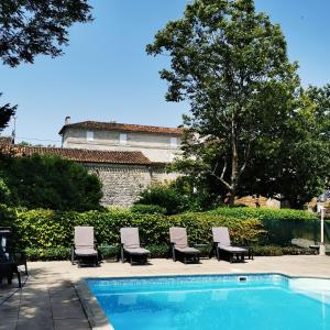 una piscina con sillas y un edificio de fondo en Gîte Le Bonheur en Hiersac