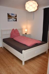 - une chambre avec un lit doté d'oreillers rouges dans l'établissement Ferienwohnung Heideggerhof, à Thaur