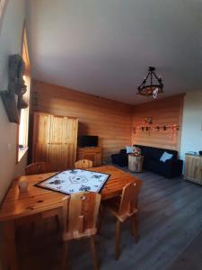 a dining room with a wooden table and a couch at Apartamenty na Szlaku in Czarny Dunajec