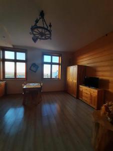 a large living room with a chandelier and wooden floors at Apartamenty na Szlaku in Czarny Dunajec