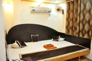 een bed in een kamer met een grote spiegel bij Hotel Vijayshree in Pachmarhī