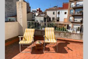 two chairs and a table on a balcony at Calella Playa in Calella
