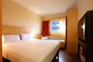 a hotel room with a large bed and a window at ibis Buenos Aires Obelisco in Buenos Aires