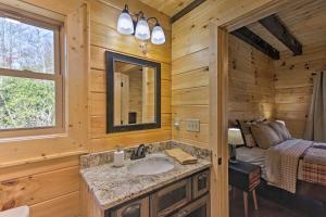 a bathroom with a sink and a bed in a room at Hilltop Cabin on 5 Acres with Hot Tub and Waterfall! in Bryson City +34 photos