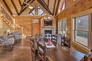 a dining room with a table and a fireplace at Hilltop Cabin on 5 Acres with Hot Tub and Waterfall! in Bryson City