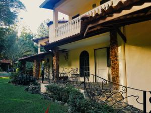 a house with a porch with chairs and a balcony at Tower Studio in the Treetops in Altos del Maria Panama in El Picacho
