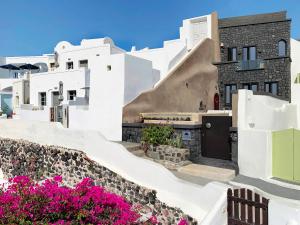 a view of a building with pink flowers at Luxury Villa Blue Dome Santorini in Imerovigli