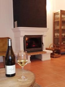 a bottle of wine and a glass of white wine at Villa bord de mer avec piscine et jacuzzi in Pénestin
