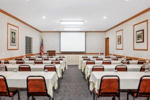 a conference room with tables and chairs and a screen at Days Inn by Wyndham Marquette in Marquette