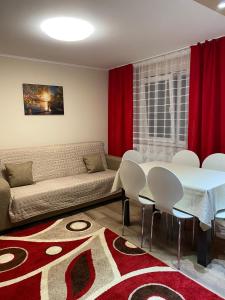 uma sala de estar com um sofá, uma mesa e cadeiras em 8 RESIDENCE APARTAMENT em Cavnic