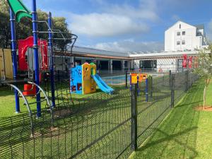 a playground in a school yard with a fence at Greenstone Ridge Apartment in Johannesburg