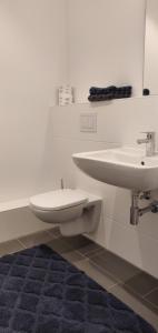 a white bathroom with a sink and a toilet at München-Riem my room Apartment an der Messe in Munich