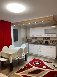 a kitchen with a white table and white chairs at 8 RESIDENCE APARTAMENT in Cavnic