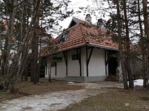 una casa bianca con un tetto rosso e alcuni alberi di Jarebika a Divčibare
