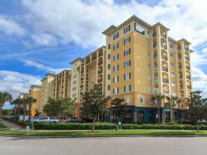 a large yellow building with a clock on it at Luxury Resort Condo, 2 or 3 BR, Premium suites in Orlando