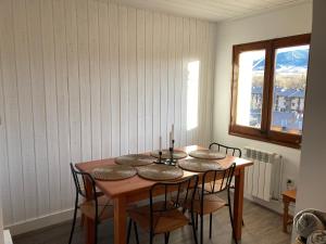 d'une salle à manger avec une table, des chaises et une fenêtre. dans l'établissement Vistas Únicas a los Pirineos, para 7-8 personas!! Tensi Home Llivia, à Llívia