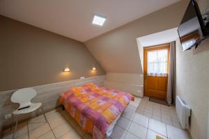 sypialnia z łóżkiem i krzesłem w pokoju w obiekcie Auberge du Tranchoir w mieście Nevoy