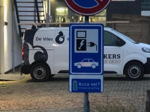 a white van parked next to a sign with a car at Marina Strand Appartement Lemmer in Lemmer