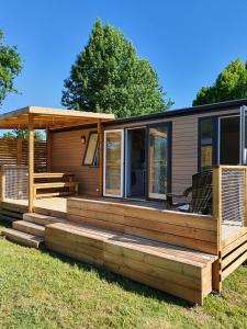 une petite maison avec une terrasse couverte et une terrasse dans l'établissement MOBIL-HOME OHARA 2020, à Biscarrosse