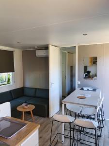 een woonkamer met een bank en een tafel en stoelen bij MOBIL-HOME OHARA 2020 in Biscarrosse