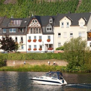 a boat in the water in front of a house at Mosel Panorama in Zell an der Mosel