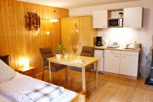 a small kitchen with a table and chairs and a kitchen with a counter at Ferienzimmer König in Breitenbrunn