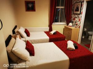 a bedroom with two beds with red and white sheets at oddfellowsbandb in Blythe