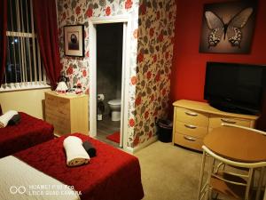 a bedroom with two beds and a flat screen tv at oddfellowsbandb in Blythe