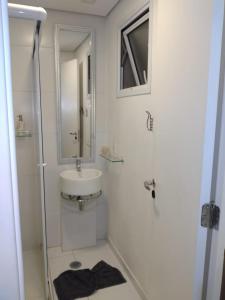 La salle de bains blanche est pourvue d'un lavabo et d'un miroir. dans l'établissement Studio 200 Downtown São Paulo, à São Paulo
